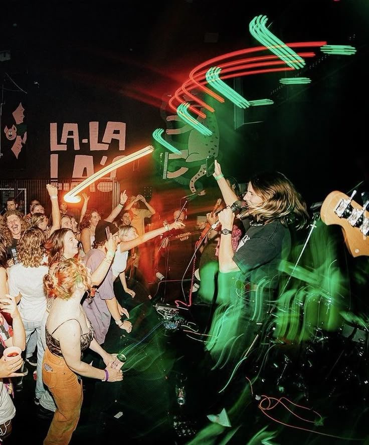 A crowd seen from the stage, lit by green lasers.